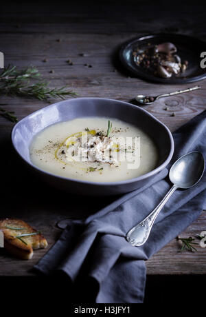 Crème de chou-fleur dans un bol de soupe avec des tranches de pain grillé sur table en bois Banque D'Images