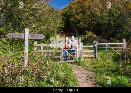 Deux marcheurs sur le chemin piétonnier à Golden Cap au bord de Langdon Woods au-dessus de Seatown, Dorset, England, UK Banque D'Images