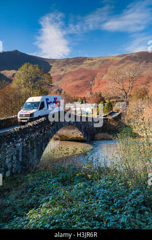 Fed Ex Delivery Van crossing Bridge Grange en automne, dans la grange de Borrowdale, Lake District, Cumbria, England, UK Banque D'Images
