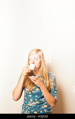 Jeune femme à boire un café espresso Banque D'Images