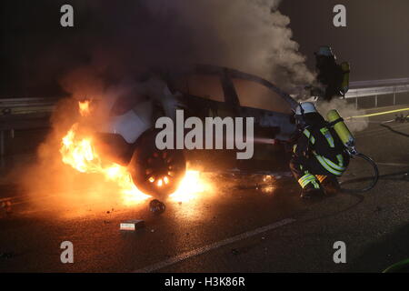 Marktoberdorf, Allemagne. 05Th Oct, 2016. Les pompiers tentent d'éteindre un feu de voiture sur l'autoroute fédérale 12 près de Marktoberdorf, Allemagne, 08 octobre 2016. Trois personnes sont mortes dans une collision frontale de leurs voitures tard 08 octobre 2016. Photo : Thorsten Bringezu/dpa/Alamy Live News Banque D'Images