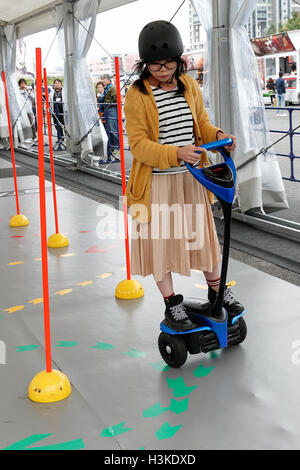 Une femme conduit une Toyota Winglet pendant le Tokyo Motor Fes 2016 à Odaiba le 10 octobre 2016, Tokyo, Japon. Le festival annuel est l'occasion pour les visiteurs de tous âges à interagir avec les véhicules à moteur depuis le japonais et étrangers d'automobiles. Les organisateurs de cette année mise en place d'un 360 degrés de réalité virtuelle (VR) Dome où les visiteurs peuvent découvrir les sensations de l'équitation à travers la réalité virtuelle. L'exposition est présentée du 8 au 10 octobre. Credit : Rodrigo Reyes Marin/AFLO/Alamy Live News Banque D'Images