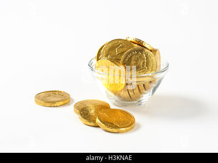 Bol de pièces en chocolat sur fond blanc Banque D'Images