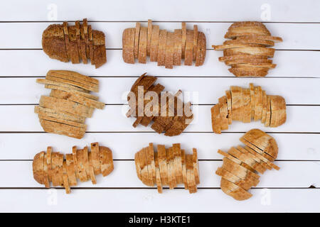 Vue du haut vers le bas sur 9 tranches de pain de blé et farine blanche divers pains sur arrière-plan du tableau blanc Banque D'Images