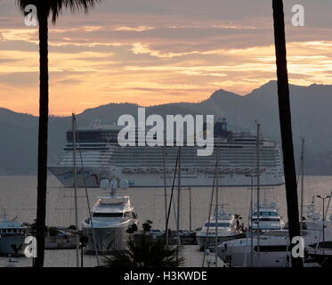 AJAXNETPHOTO. 2016. CANNES, FRANCE. - Côte D'AZUR RESORT - À L'OUEST À TRAVERS LA BAIE DE CANNES AVEC Norwegian Cruise Line's Norwegian Epic CRUISE SHIP ANCRÉ DANS LA BAIE AU COUCHER DU SOLEIL ET SUPER YACHTS ET VEDETTE À MOTEUR AMARRÉ DANS LA MARINA DE PORT PIERRE CANTO (premier plan). PHOTO:JONATHAN EASTLAND/AJAX REF:GX160710 6440 Banque D'Images