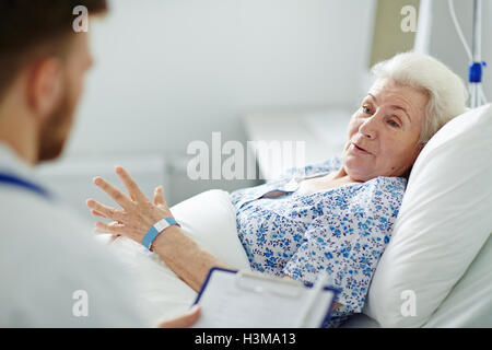 Patients âgés de son médecin indiquant comment elle se sent Banque D'Images