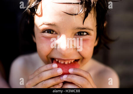 Happy boy eating watermelon on summer day Banque D'Images