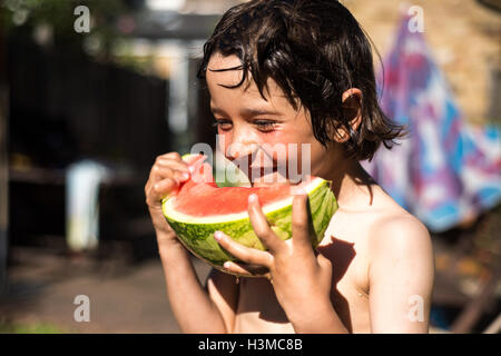 Happy boy eating watermelon on summer day Banque D'Images