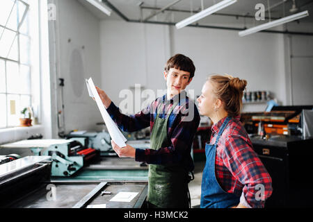 Les jeunes hommes et femmes à la recherche d'artisan à l'atelier des arts de livre Banque D'Images