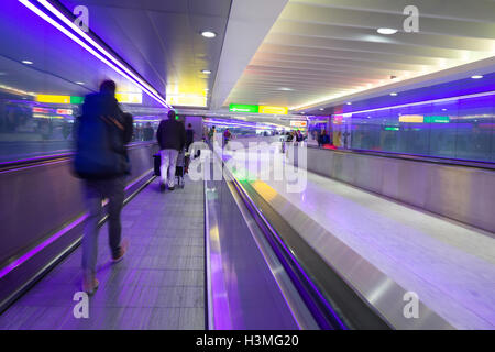 Vitesse d'obturation lente utilisée pour enregistrer les mouvement exagéré des voyageurs au terminal de l'aéroport Heathrow de Londres, Royaume-Uni, Banque D'Images