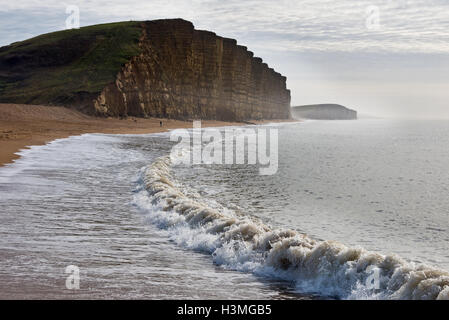 Vue d'une soirée de West Bay pier à la recherche le long de la plage vers l'East Cliff Burton et Falaise sur Dorsets côte jurassique Banque D'Images