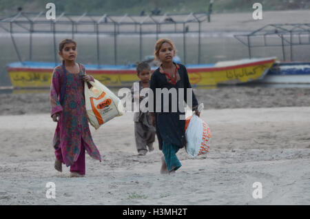 Lahore, Pakistan. 10 Oct, 2016. Les filles jouant au gypsy pakistanais la banque du fleuve ravi près de chez elle des maisons de fortune à la veille de la Journée internationale de la fille à Lahore. Journée internationale de la fille est une célébration internationale jour déclaré par les Nations Unies, il est également appelé le jour de la jeune fille et la Journée internationale de la fille. © Rana Sajid Hussain/Pacific Press/Alamy Live News Banque D'Images