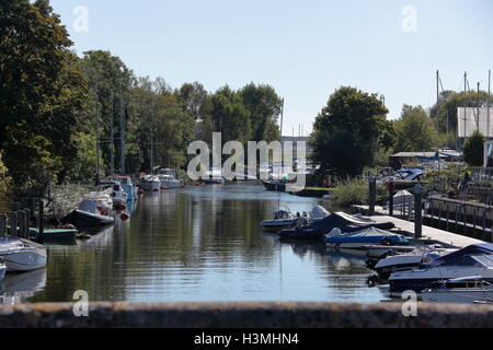 Vue sur la rivière avec de nombreux et divers bateaux amarrés sur les deux côtés le long des rives avec des eaux calmes et de ciel bleu. Banque D'Images