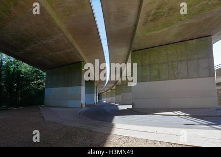 Jusqu'à sous les arches d'un pont en béton incurvé énorme avec un espace entre les deux chaussées. Banque D'Images