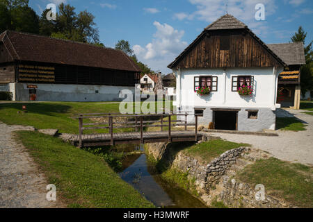 Maison traditionnelle et de bâtiments par un ruisseau de Kumrovec, Croatie Banque D'Images