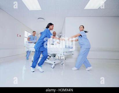 Médecin et patient médical fonctionnant avec lit dans l'urgence d'un hôpital Banque D'Images