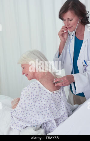 Femme médecin à l'écoute des femmes senior patient with stethoscope Banque D'Images