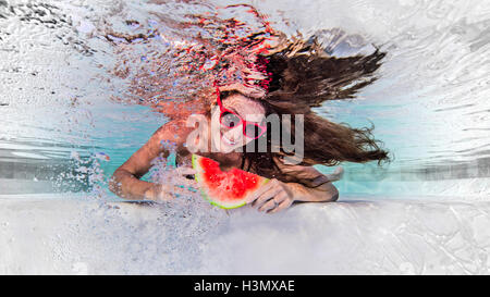 Sous-vue de femme portant des lunettes de soleil, manger tranche de melon d'eau, smiling Banque D'Images