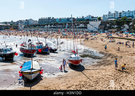 Bateaux de pêche dans l'avant-plan avec la plage derrière bondés de gens pendant l'été à la ville de villégiature de Broadstairs Kent. Banque D'Images