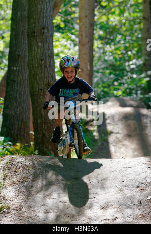 Un jeune (4 ans) boy riding son vélo dans le bois sur un vélo de montagne pompe voie Banque D'Images