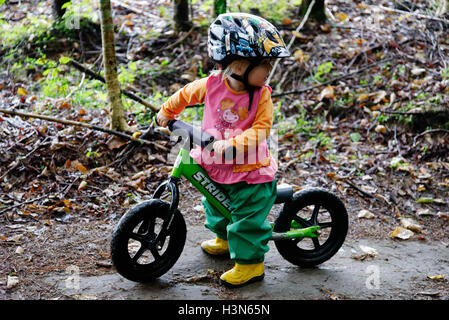 Une fillette de deux ans sur une balance bike Banque D'Images