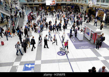 Les gens du voyage et les navetteurs à vélo cycliste avec d'attente debout dans le grand hall à l'intérieur de la gare de Liverpool Street, London UK KATHY DEWITT Banque D'Images