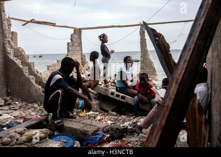 Les Cayes, Haïti. 9 octobre, 2016. Image fournie par l'Organisation des Nations Unies pour l'enfance (UNICEF) montre des gens assis sur une structure dévastée par l'Ouragan Matthew, dans le quartier de la Savane, Les Cayes, Haïti, le 9 octobre 2016. Au moins 1,4 millions de personnes ont besoin d'aide à la suite de l'Ouragan Matthew, le Secrétaire général des Nations Unies Ban Ki-moon a déclaré aux journalistes lundi. © UNICEF/Xinhua/Alamy Live News Banque D'Images