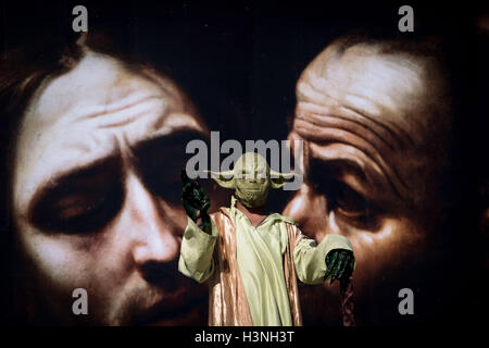 Londres, Royaume-Uni. 11 octobre, 2016. Un artiste de rue Yoda flottant en face d'une grande affiche "au-delà de la promotion de l'exposition Caravaggio en dehors de Londres, National Gallery à Trafalgar Square. Crédit : Guy Josse/Alamy Live News Banque D'Images