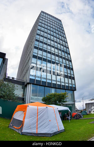 Manchester, UK. 11 octobre, 2016. Un jeune homme, Chris de Salford, grimpa sur le toit de la maison en fonction du pont Ducie Street Miller à 8-o-réveil ce matin pour protester contre l'expulsion de 30 personnes sans abri qui ont été accroupis dans l'immeuble pendant plusieurs semaines. Les agents d'application de la Haute Cour acquise entrée du bâtiment, propriété de la société coopérative, tôt ce matin, d'expulser les squatters qui ont été défiant un haute cour d'expulsion. Crédit : Dave Ellison/Alamy Live News Banque D'Images