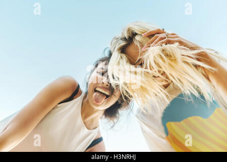 Low angle view of young women smiling at camera Banque D'Images