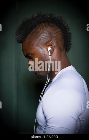 Profil de jeune homme avec le mohawk wearing earphones Banque D'Images