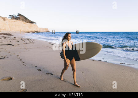 Surfer avec surfboard on beach, Santa Cruz, Californie, USA Banque D'Images