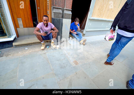 Londres, Angleterre, Royaume-Uni. Ouvriers assis sur le trottoir, de manger et de fumer Banque D'Images