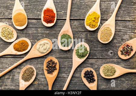 Épices diverses dans des cuillères en bois sur la vieille table en bois. Vue d'en haut. Banque D'Images