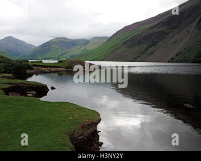 Vue vers le haut du plus profond lac Wastwater Angleterre vers Wasdale Head & Grand Gable dans Cumbria avec rock pierriers reflète dans l'eau Banque D'Images