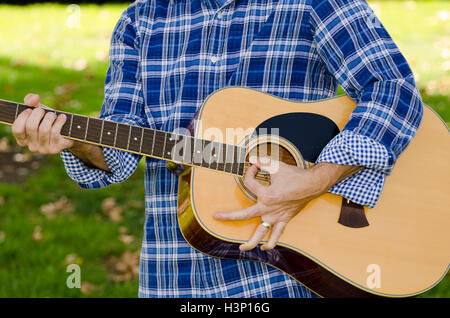 Libre de l'homme jouant une guitare portant une chemise à carreaux. Banque D'Images