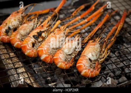 Gambas black tiger étant grillées sur charbon de bois à un étal au marché Gor Tor ou à Bangkok. Banque D'Images