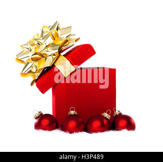Cadeaux de Noël rouge avec ruban d'or entourée d'ornements babiole rouge sur un fond blanc. Banque D'Images