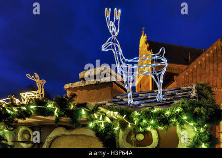 Cerf lumineux figure sur le dessus de la bloquer en cours du marché de Noël dans la vieille ville de Riga, Lettonie. Le marché a lieu à travers la vieille ville et en particulier sur la place du Dôme, en plein coeur de la ville. Banque D'Images