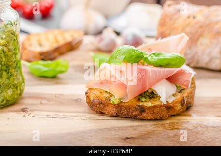 Crostini avec jambon forêt noire, fromage Parmesan et pesto au basilic Banque D'Images