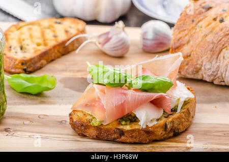 Crostini avec jambon forêt noire, fromage Parmesan et pesto au basilic Banque D'Images