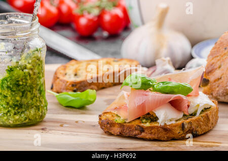 Crostini avec jambon forêt noire, fromage Parmesan et pesto au basilic Banque D'Images