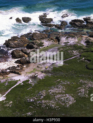 Quatre roues roulant sur une piste à distance et côte sauvage, Banque D'Images