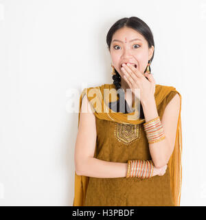 Portrait of young Indian Chinese girl en robe traditionnelle punjabi couvrant sa bouche, surpris de l'émotion, Comité permanent Banque D'Images