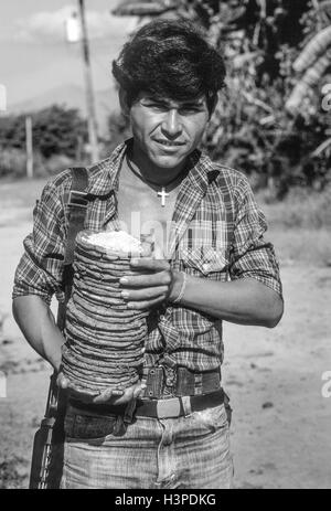 TENANCINGO, EL SALVADOR, mars 1984 : - dans le FPL Les zones de contrôle. Un chasseur de FPL avec une pile de tortillas et de sel. Banque D'Images