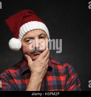 Pensez à Noël dans la solitude et la tristesse. Un homme âgé dans la réflexion sur les cadeaux de Noël Banque D'Images