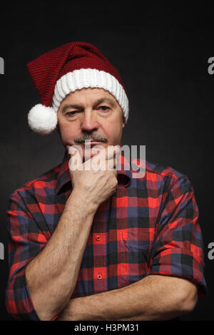 Pensez à Noël dans la solitude et la tristesse. Un homme âgé dans la réflexion sur les cadeaux de Noël Banque D'Images