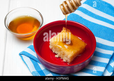 Basbousa - arabian cake aux amandes et sirop de miel dans un bol blanc sur fond de bois Banque D'Images