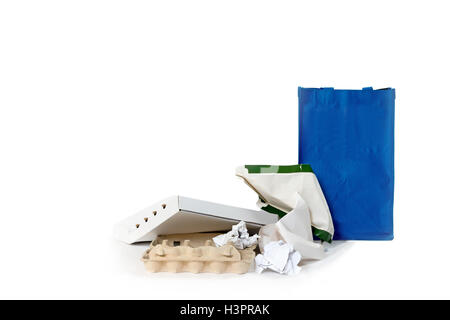 Pile de papier est posée sur le fond blanc. Le sac bleu vide est debout à côté d'eux. Banque D'Images