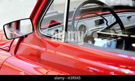 Vue de côté au moyen d'une fenêtre à l'intérieur de la ligne Classic vintage voiture rouge. Banque D'Images